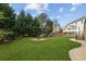 Private backyard with lush lawn, mature trees, in-ground fire pit, and extended patio at 3465 Caney Creek Ln, Cumming, GA 30041