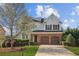 Charming two-story home featuring a brick facade, attached two-car garage, landscaped front yard, and a welcoming entrance at 3465 Caney Creek Ln, Cumming, GA 30041