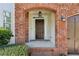Inviting front entrance featuring a brick archway, dark wood door with sidelights, and classic lantern lighting at 3465 Caney Creek Ln, Cumming, GA 30041