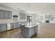 Spacious kitchen with gray cabinets, stainless appliances, central island, open to living area at 3465 Caney Creek Ln, Cumming, GA 30041