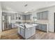 Open concept kitchen features gray cabinets, stainless steel appliances, and center island with quartz countertops at 3465 Caney Creek Ln, Cumming, GA 30041