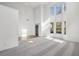 Bright, open-concept living room with soaring ceilings, large windows, and neutral carpet at 3465 Caney Creek Ln, Cumming, GA 30041