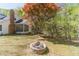 Backyard view features a stone fire pit, mature trees, and partial view of the house at 3775 Belle Glade Trl, Snellville, GA 30039