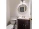 Cozy half bath with a modern vanity and a stylish round mirror to compliment the fixtures and design at 3775 Belle Glade Trl, Snellville, GA 30039
