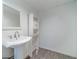 Basement bathroom showcasing pedestal sink, white walls, and cabinet space offers convenience at 3775 Belle Glade Trl, Snellville, GA 30039