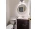 Small, stylish half-bath with round mirror and a dark vanity offers a modern design at 3775 Belle Glade Trl, Snellville, GA 30039