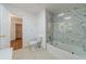 Renovated bathroom featuring a tiled shower and bathtub with a marble-patterned tile surround at 3775 Belle Glade Trl, Snellville, GA 30039