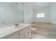 This bathroom features a tiled tub, bright white vanity, and lots of natural light from its stained glass window at 3775 Belle Glade Trl, Snellville, GA 30039