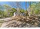 Scenic view of a long driveway leading to a charming home surrounded by mature trees at 3775 Belle Glade Trl, Snellville, GA 30039