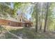 Back of a two-story home featuring a wooden deck, brick foundation, and wooded backyard at 3775 Belle Glade Trl, Snellville, GA 30039