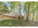 Back of a two-story home featuring a wooden deck, brick foundation, and wooded backyard at 3775 Belle Glade Trl, Snellville, GA 30039