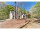 Detached garage and long driveway leading up to a beautiful white home, surrounded by mature trees at 3775 Belle Glade Trl, Snellville, GA 30039