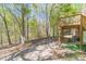Back of the property featuring a covered deck, lush trees, and parking area with a concrete driveway at 3775 Belle Glade Trl, Snellville, GA 30039