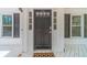 Close-up of a modern front door with sidelights, black hardware, and a stylish doormat, creating a welcoming entry at 3775 Belle Glade Trl, Snellville, GA 30039