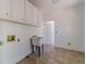 Bright laundry room with tiled floor, white cabinets, and wash sink at 3775 Belle Glade Trl, Snellville, GA 30039
