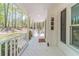 Covered porch with white railing offers a view of a private wooded yard at 3775 Belle Glade Trl, Snellville, GA 30039