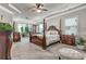 Elegant main bedroom features a four-poster bed, tray ceiling, and bright natural light at 609 Eskimo Ct, Cts, Hampton, GA 30228