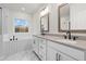 Bright bathroom with double vanities, modern fixtures, soaking tub, and natural light from a window at 683 Summitt Hill Way, Cumming, GA 30040