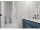 Bathroom with navy vanity, marble countertops, with view of shower and toilet room at 683 Summitt Hill Way, Cumming, GA 30040