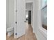 Bright hallway view featuring wood-look flooring and a glimpse into an adjacent powder room at 683 Summitt Hill Way, Cumming, GA 30040