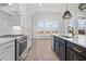 A modern kitchen with stainless steel appliances, white cabinetry, and an island with a sink at 683 Summitt Hill Way, Cumming, GA 30040