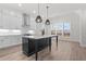 Modern kitchen with an island, pendant lighting, white cabinets, and stainless steel appliances at 683 Summitt Hill Way, Cumming, GA 30040