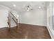 Open living room featuring hardwood floors, a ceiling fan, and natural light through large windows at 683 Summitt Hill Way, Cumming, GA 30040