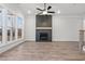 Bright living room featuring wood-look floors, fireplace, and oversized windows at 683 Summitt Hill Way, Cumming, GA 30040