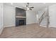 Bright living room with wood-look floors, fireplace, staircase, and natural light at 683 Summitt Hill Way, Cumming, GA 30040