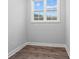 A simple room with light hardwood floors, white walls, and natural light through a window at 683 Summitt Hill Way, Cumming, GA 30040