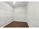 Walk-in closet with wood floors and multiple wire shelving units installed around the perimeter at 683 Summitt Hill Way, Cumming, GA 30040