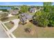 Aerial of a brick home, circular driveway, and lush landscaping, near lake, offering a blend of luxury and nature at 755 Peninsula Overlook, Hampton, GA 30228