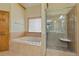 Bathroom with soaking tub, separate glass shower, tile floors, and wood cabinets at 755 Peninsula Overlook, Hampton, GA 30228