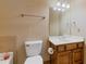 Bathroom featuring a wooden vanity, toilet, and framed mirror with modern lighting at 755 Peninsula Overlook, Hampton, GA 30228