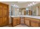 Bathroom with double sinks, wood cabinets, tile floors, and large mirrors at 755 Peninsula Overlook, Hampton, GA 30228