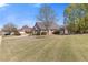 Traditional-style home with a sprawling lawn, mature trees, and a brick facade, offering classic suburban charm at 755 Peninsula Overlook, Hampton, GA 30228