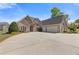 Beautiful brick home featuring an expansive driveway leading to a spacious three-car garage at 755 Peninsula Overlook, Hampton, GA 30228