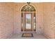 Elegant front door with decorative glass, sidelights, and brick surround at 755 Peninsula Overlook, Hampton, GA 30228