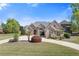 Charming brick home with lush landscaping, a circular driveway, and a well-manicured lawn at 755 Peninsula Overlook, Hampton, GA 30228