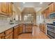 Kitchen with wooden cabinets, granite countertops, stainless appliances, and hardwood floors at 755 Peninsula Overlook, Hampton, GA 30228