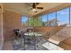 Screened patio featuring brick walls, ceiling fan, table, chairs, and view of backyard at 755 Peninsula Overlook, Hampton, GA 30228