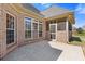 Enclosed brick patio featuring windows and a screen door, with a view of the backyard at 755 Peninsula Overlook, Hampton, GA 30228
