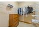 Walk-in closet featuring shelving, hanging rods, wooden dresser, and neutral carpeting at 755 Peninsula Overlook, Hampton, GA 30228