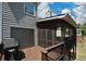 Outdoor porch area featuring a grill, wooden flooring, and a screened room at 1052 Secret Ne Trl, Sugar Hill, GA 30518