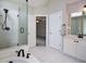 Bright bathroom featuring white tile floors, walk-in glass shower, soaking tub and bright lighting at 1052 Secret Ne Trl, Sugar Hill, GA 30518