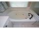 Soaking tub with jets, black fixtures, and white tile, creating a luxurious and relaxing spa-like experience at 1052 Secret Ne Trl, Sugar Hill, GA 30518