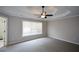 Spacious bedroom with neutral walls, a ceiling fan, large windows and an ensuite bathroom featuring tiled shower stall at 1052 Secret Ne Trl, Sugar Hill, GA 30518