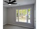 Well-lit bedroom featuring a window view, neutral walls and carpet, and a ceiling fan at 1052 Secret Ne Trl, Sugar Hill, GA 30518