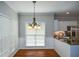 Sunlit breakfast nook features hardwood floors, a hanging chandelier, and large windows at 1052 Secret Ne Trl, Sugar Hill, GA 30518