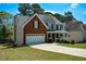 View of the property showing the garage, lawn, and partial view of the adjacent house at 1052 Secret Ne Trl, Sugar Hill, GA 30518